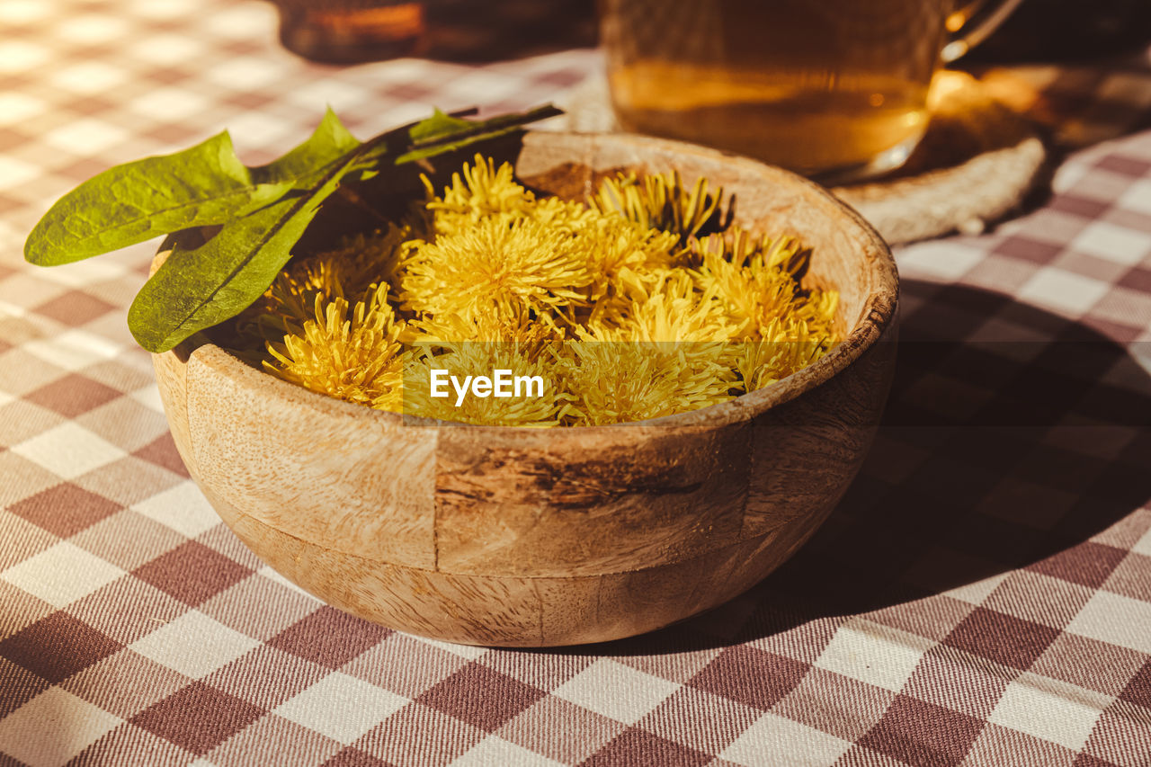 Preparing dandelion flower healthy tea in glass cup on table. herbal medicine delicious tisane tea