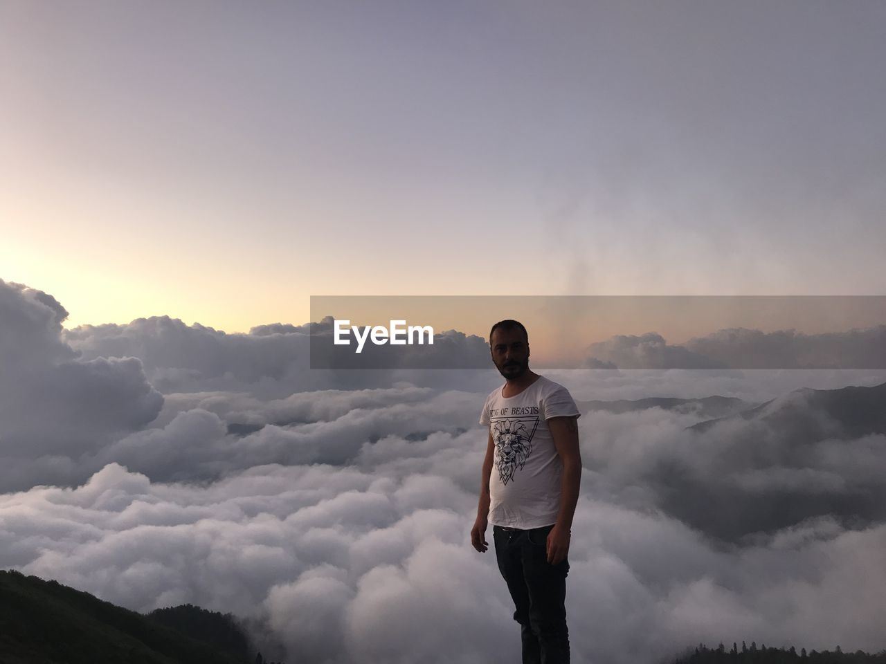 YOUNG MAN STANDING AGAINST SKY