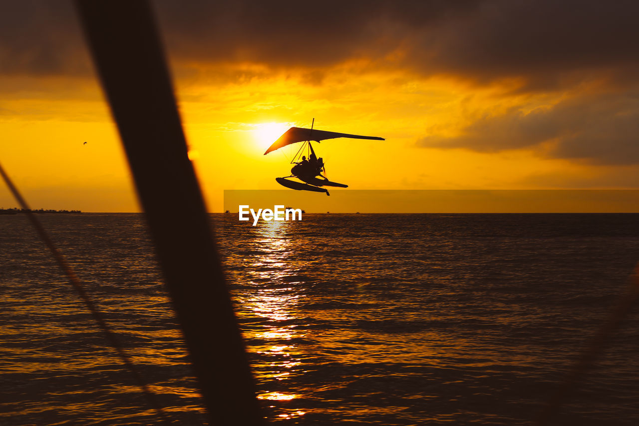 An hang glider flies over the sea at sunset. summer activities. sport. high quality photo