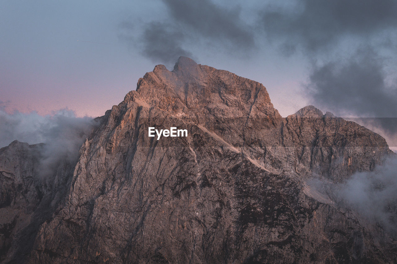 Background photo of low clouds in a mountain valley, vibrant blue and orange pink sky