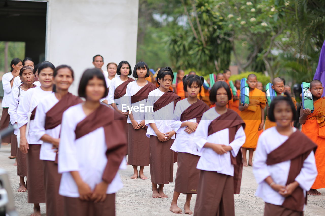 GROUP OF PEOPLE STANDING AGAINST THE WALL