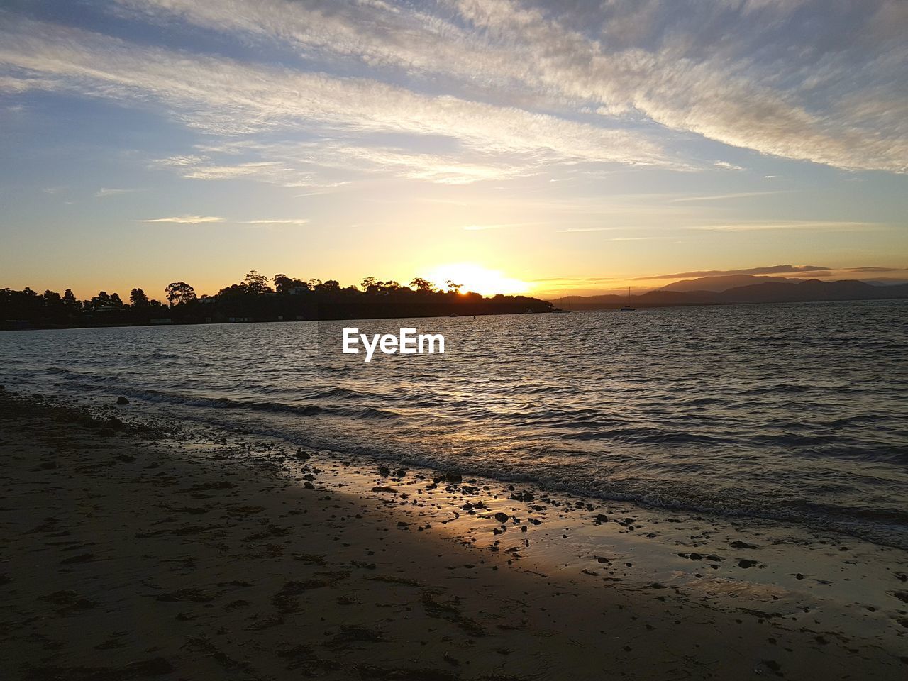 SCENIC VIEW OF BEACH AT SUNSET