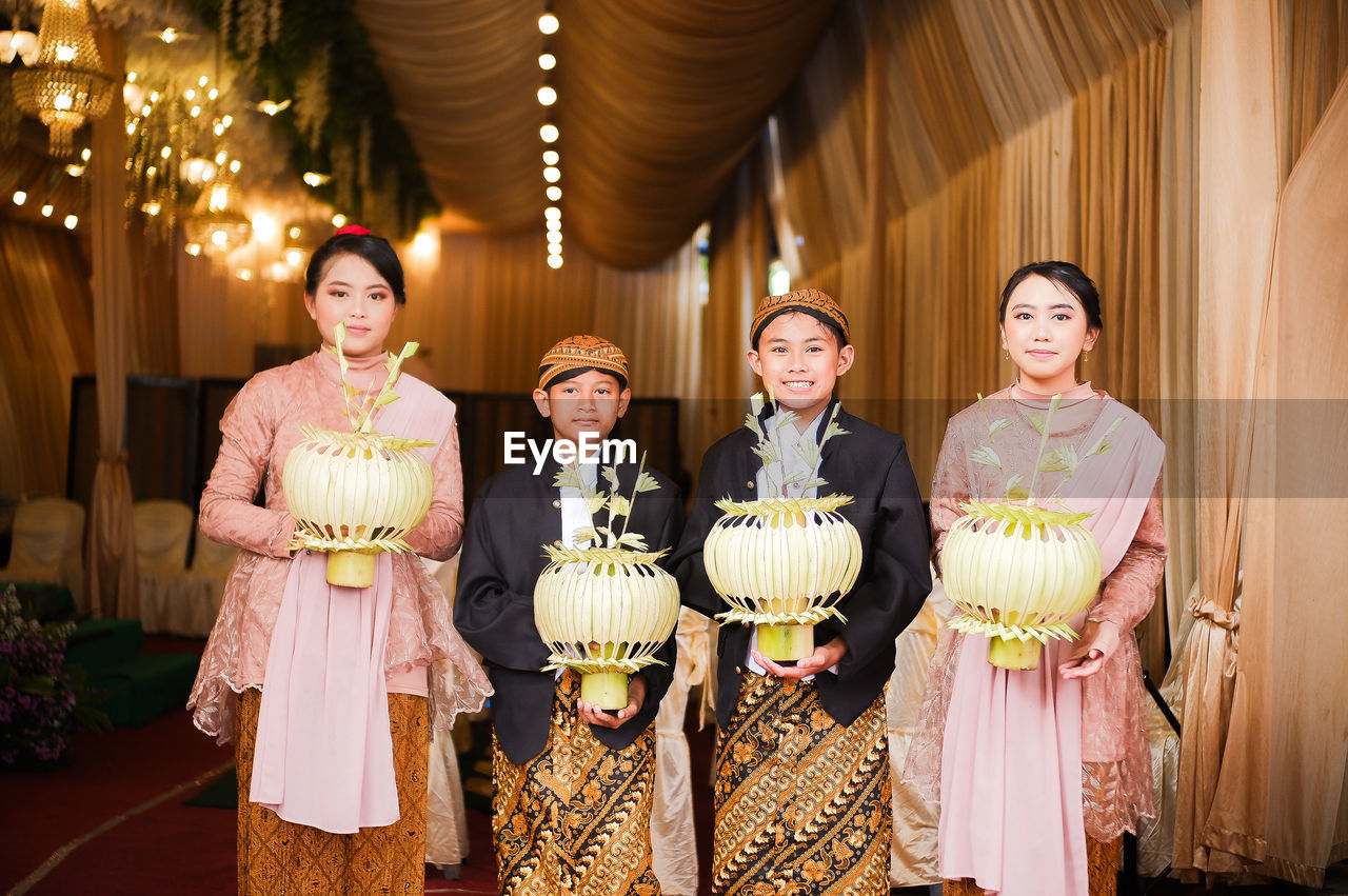 smiling, women, adult, happiness, ceremony, wedding, group of people, female, looking at camera, portrait, clothing, emotion, indoors, standing, celebration, wedding reception, togetherness, men, person, traditional clothing, event, bride, tradition, child, cheerful, young adult, dress, mature adult, elegance, three quarter length, childhood