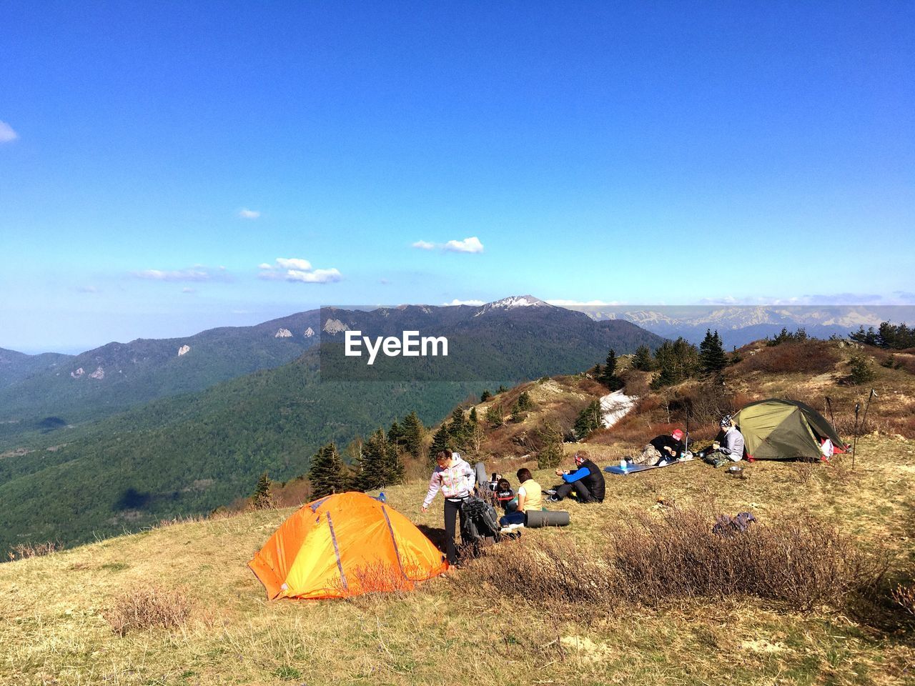 PEOPLE ON LANDSCAPE AGAINST MOUNTAINS