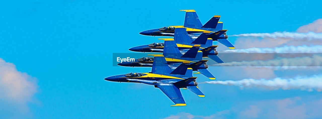 Panoramic view of fighter planes performing airshow in blue sky