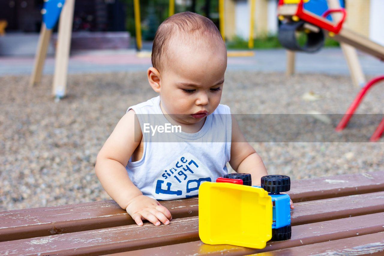 Cute happy smiling baby boy at playground outdoors