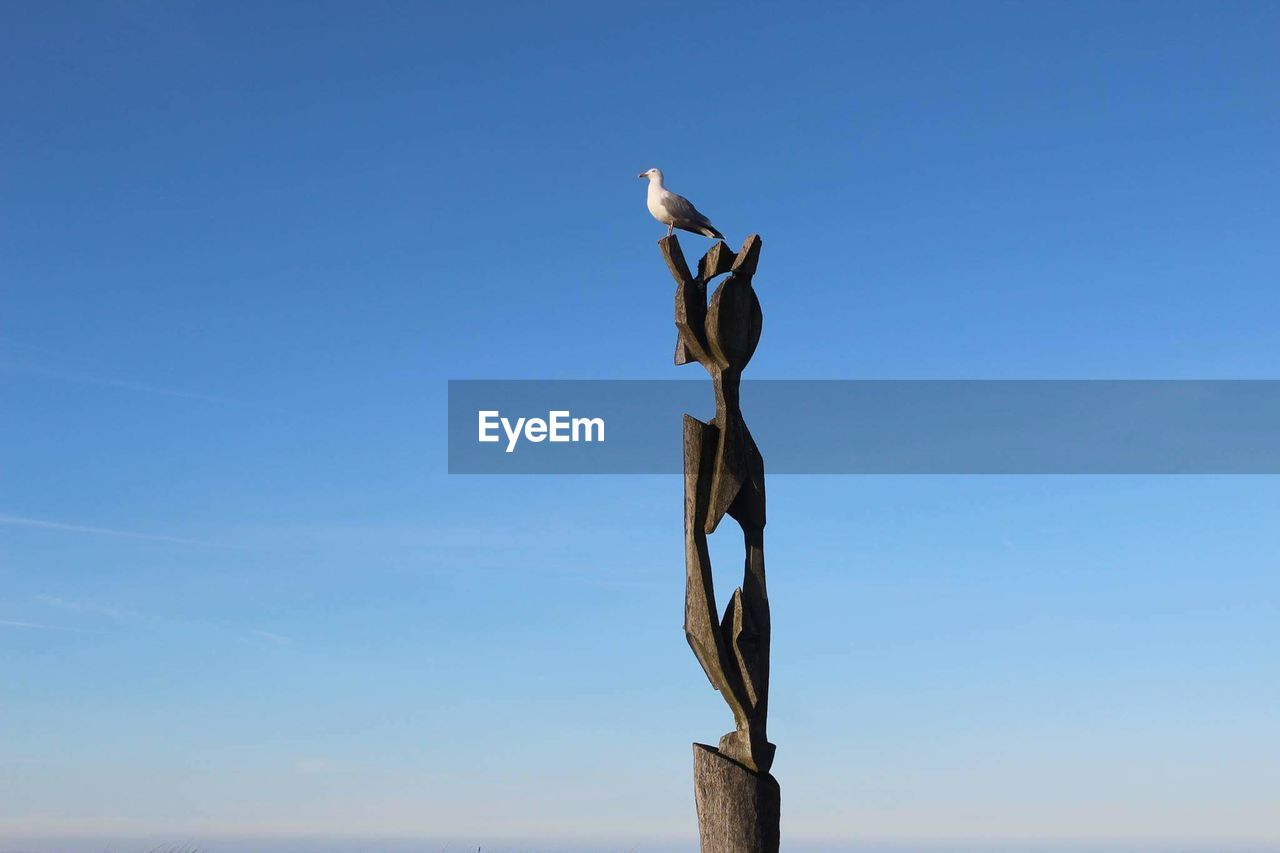 LOW ANGLE VIEW OF SCULPTURE AGAINST CLEAR BLUE SKY