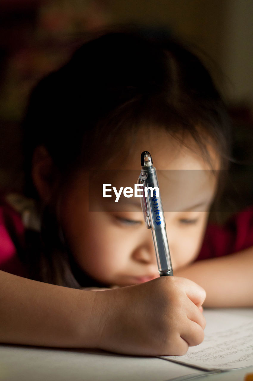 Close-up of girl writing in book