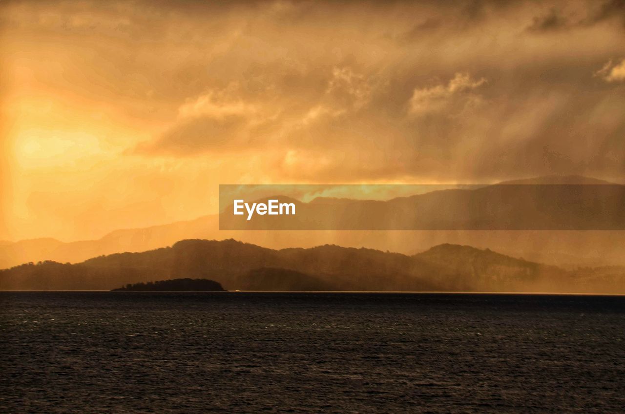 SCENIC VIEW OF SEA AND MOUNTAINS AGAINST SKY