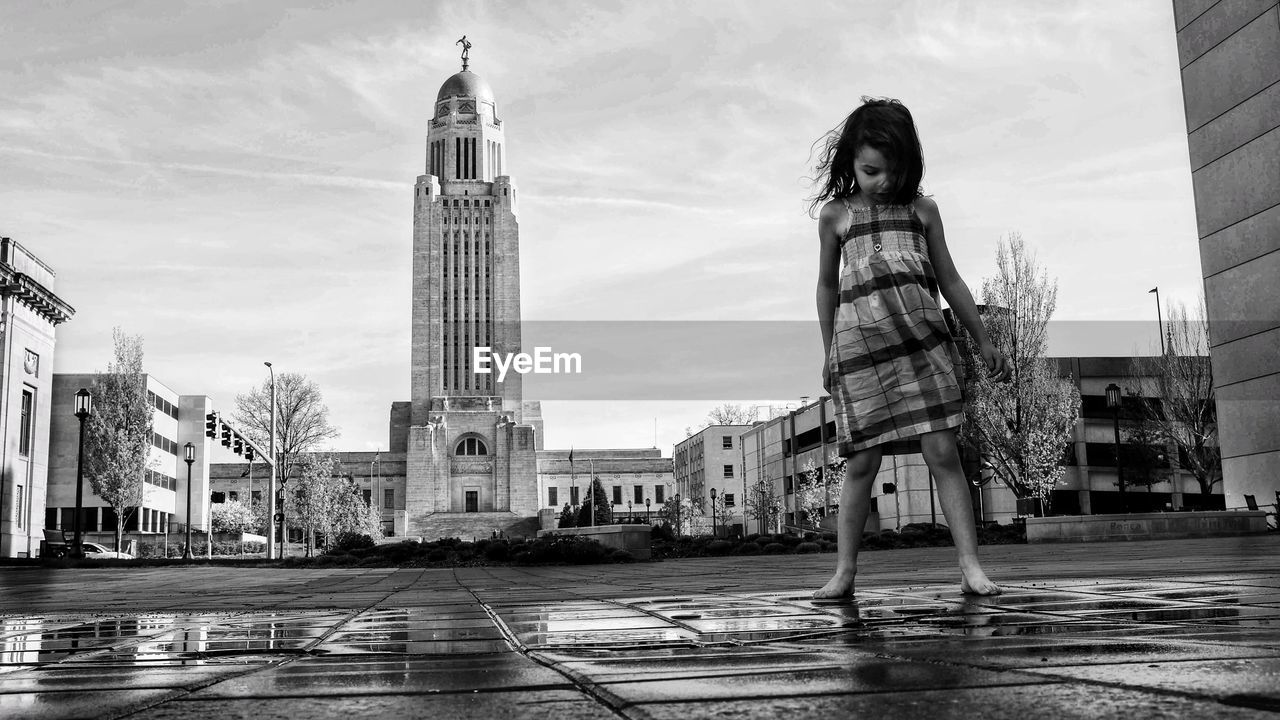 Girl standing against nebraska state capitol building 