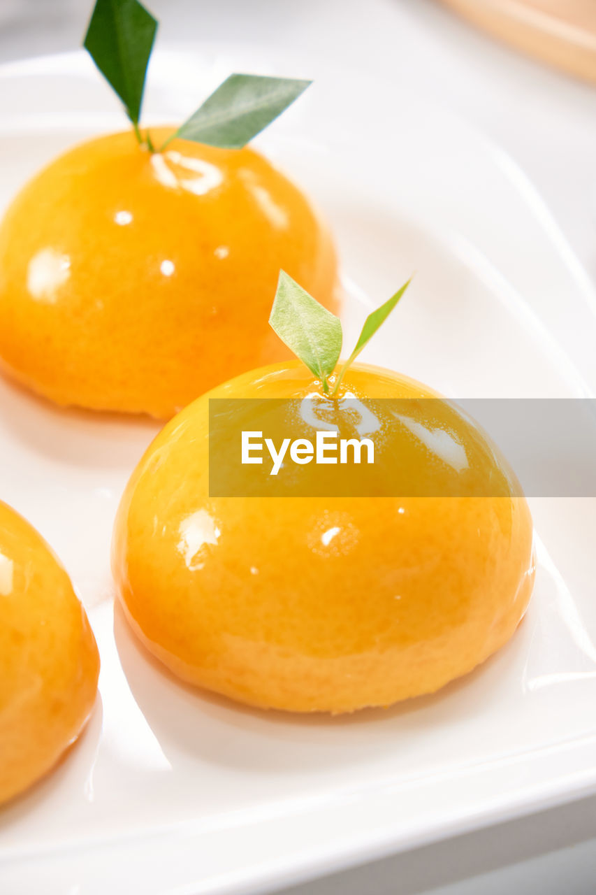 HIGH ANGLE VIEW OF ORANGE SLICES IN PLATE