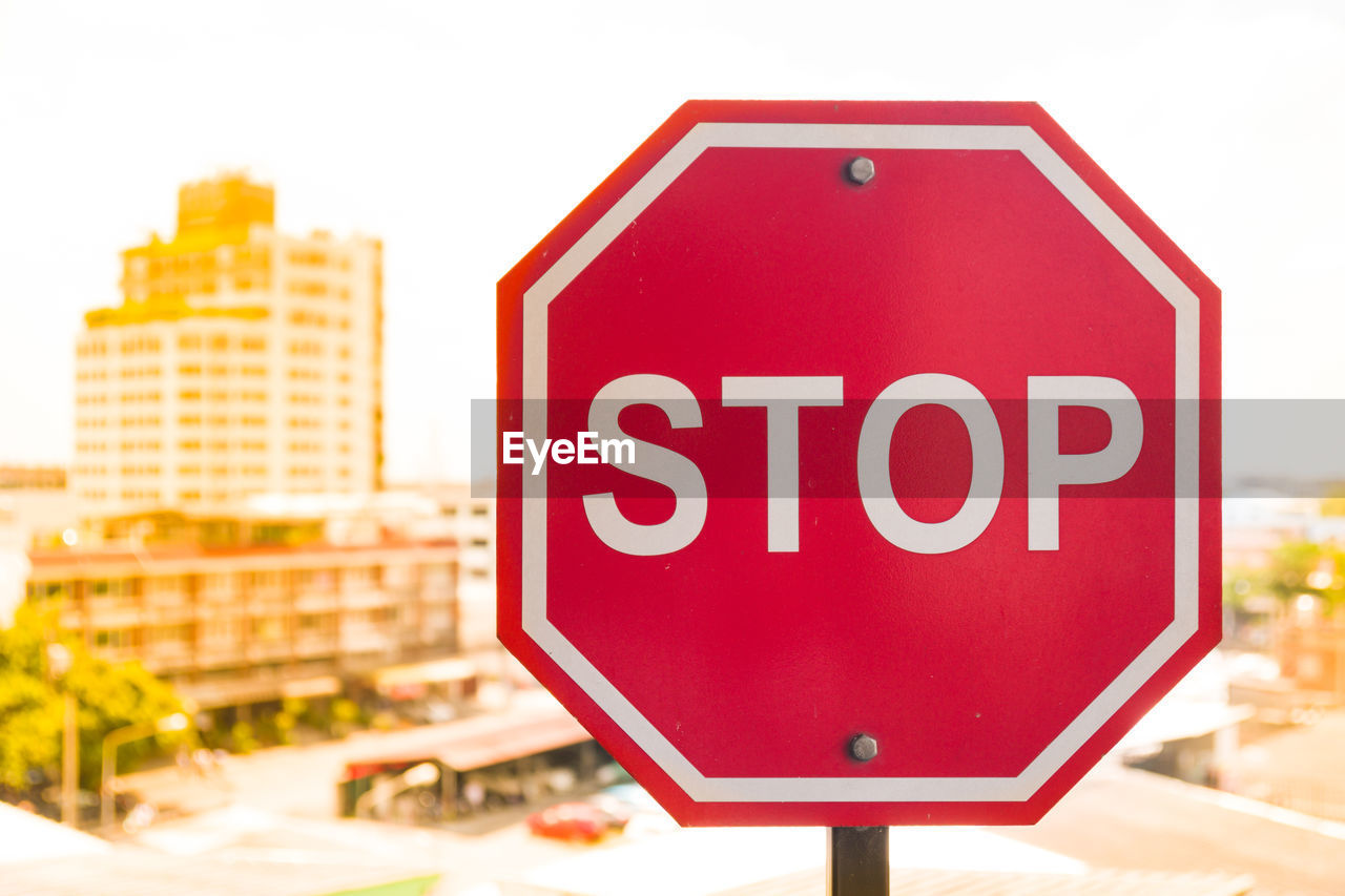 Close-up of stop sign in city against clear sky