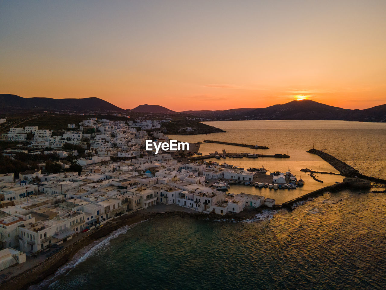 High angle view of townscape, naoussa paros, by sea against sky during sunset