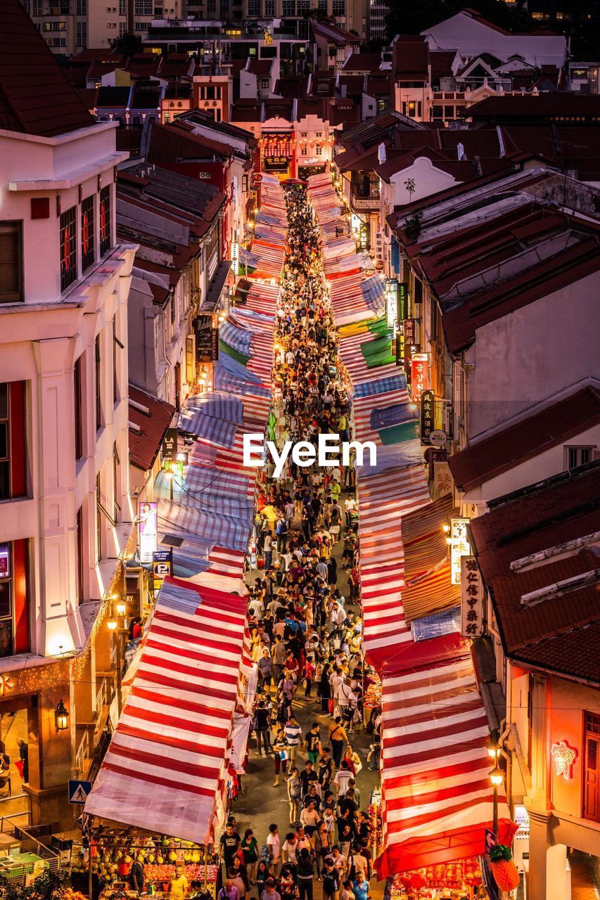 High angle view of people by illuminated buildings at night