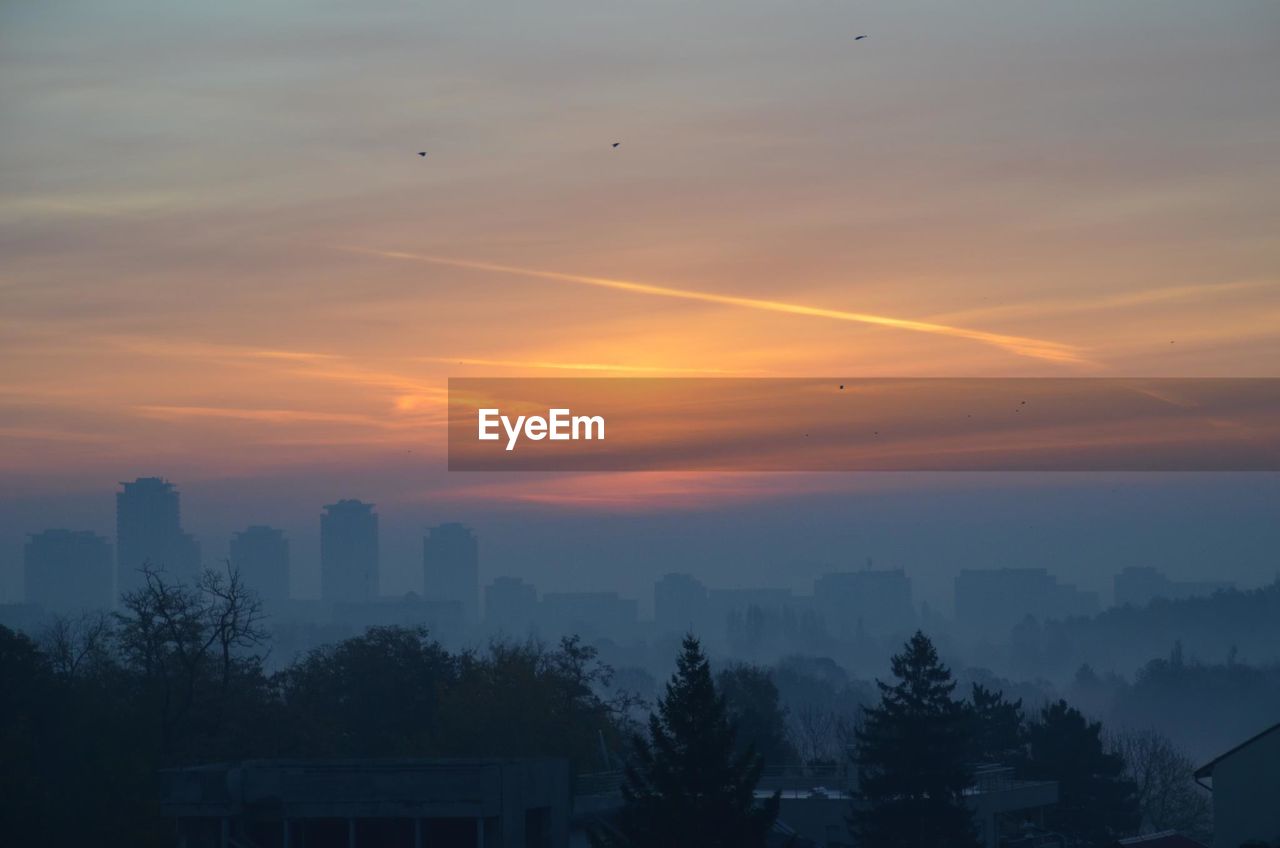 SILHOUETTE BUILDINGS AGAINST SKY DURING SUNSET