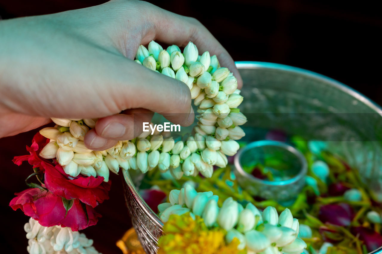 Close-up of hand holding floral garland