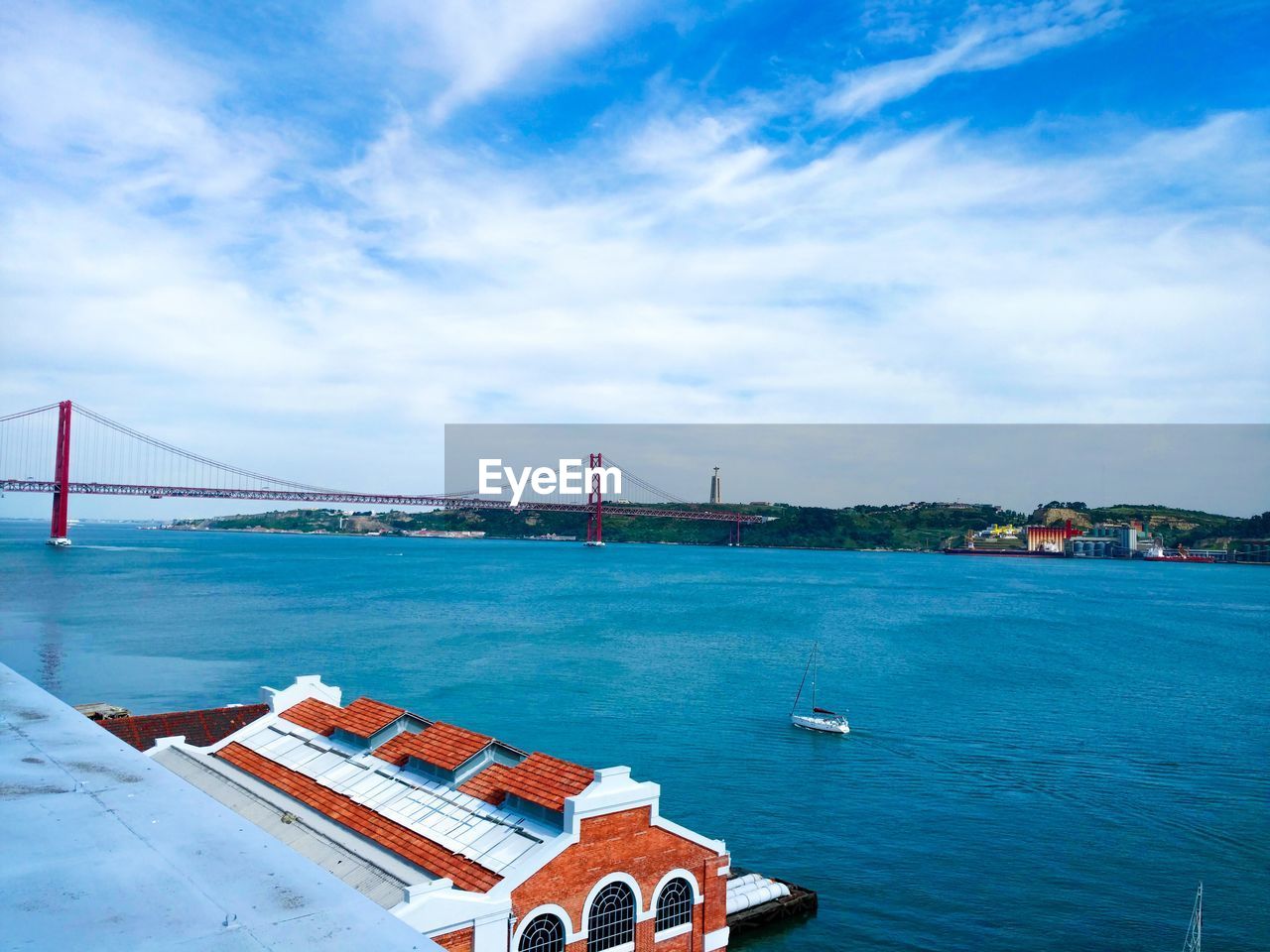 April 25th bridge over tagus river against cloudy sky