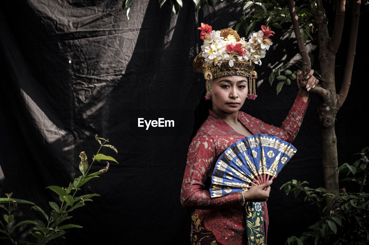 Portrait of woman wearing traditional clothing standing in forest