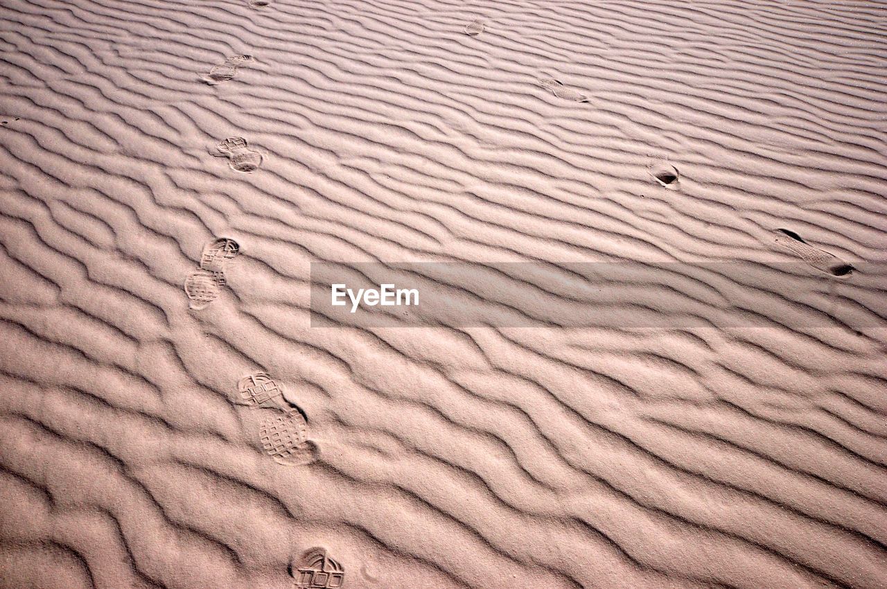 High angle view of footprints on sand at beach