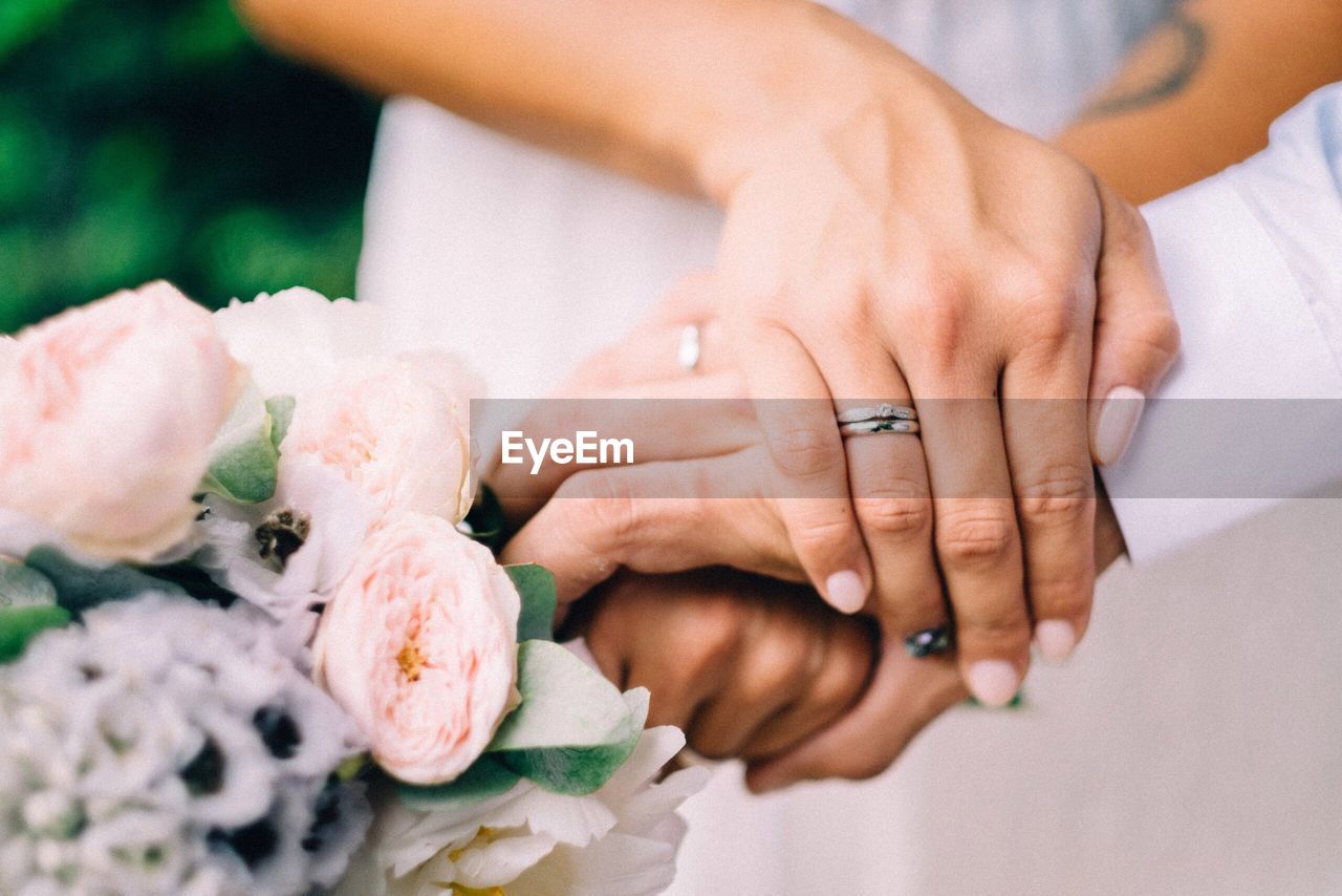 Cropped image of wedding couple holding hands