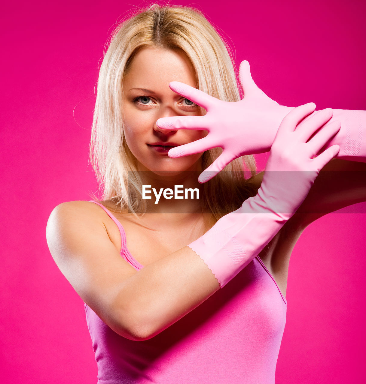 Portrait of pregnant woman exercising standing against pink background