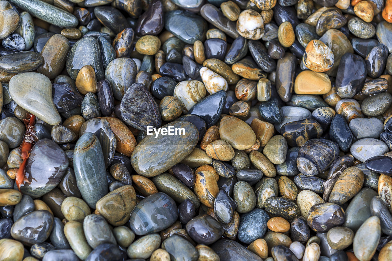 FULL FRAME SHOT OF PEBBLES ON STONES