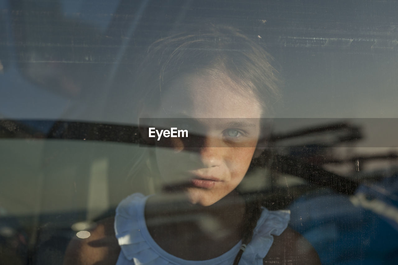 Portrait of girl seen through glass window