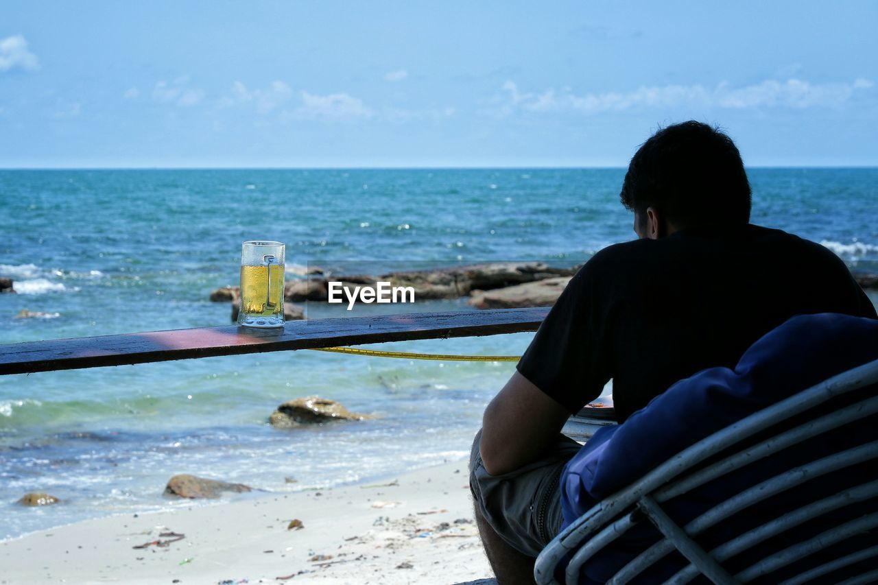 WOMAN SITTING ON BEACH