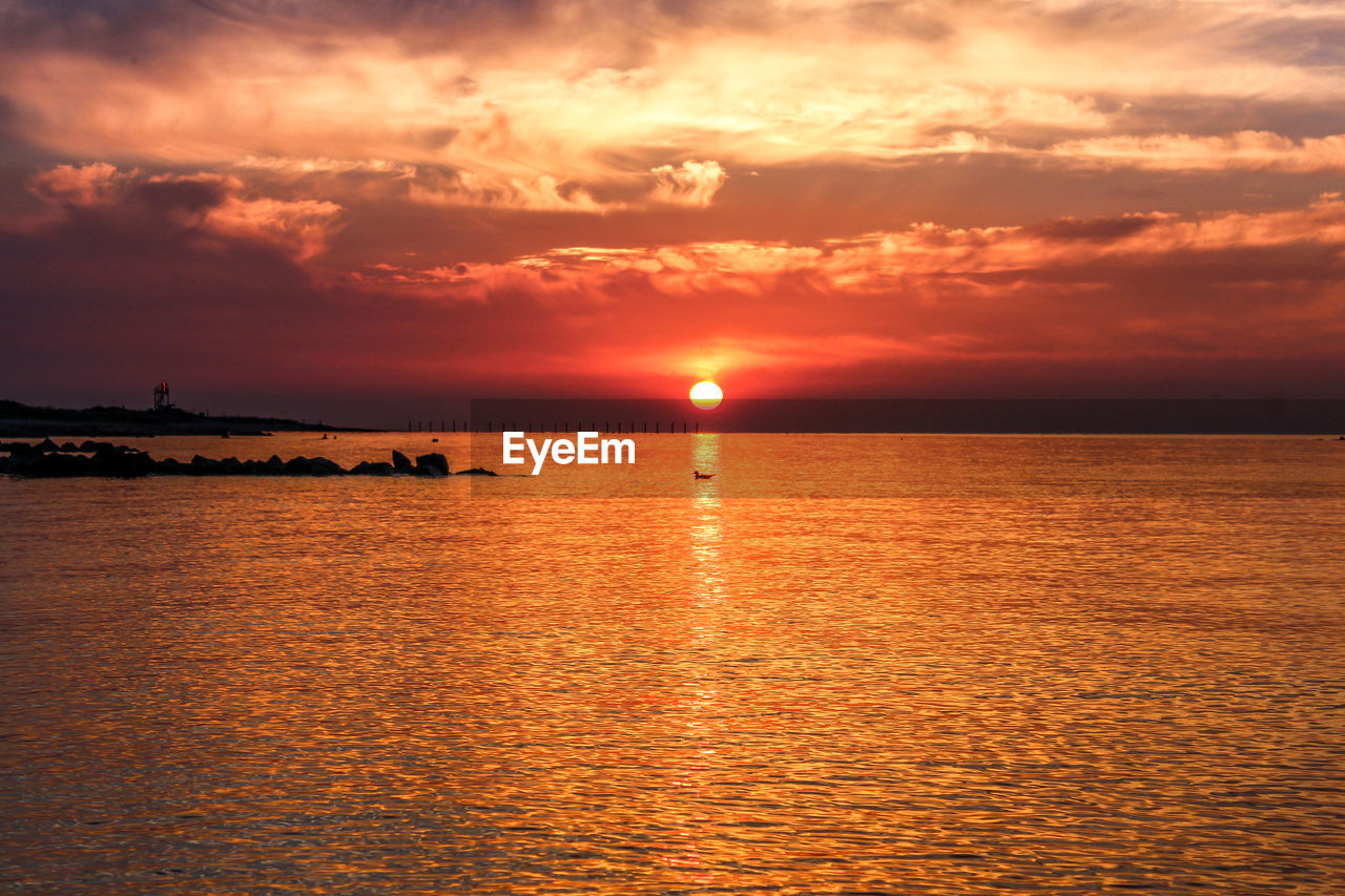 Scenic view of sea against orange sky during sunset