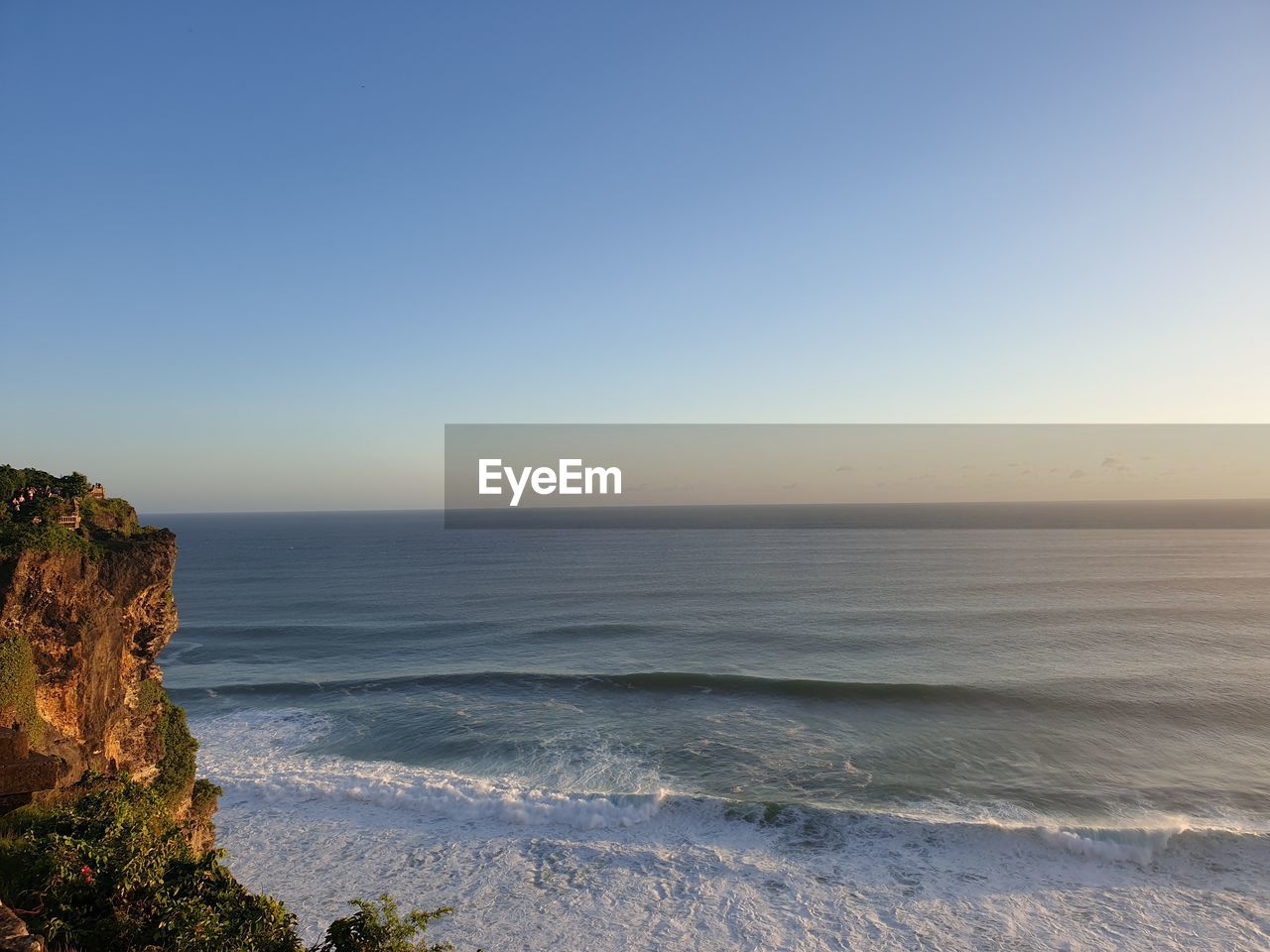 SCENIC VIEW OF SEA AGAINST CLEAR SKY AT SUNSET