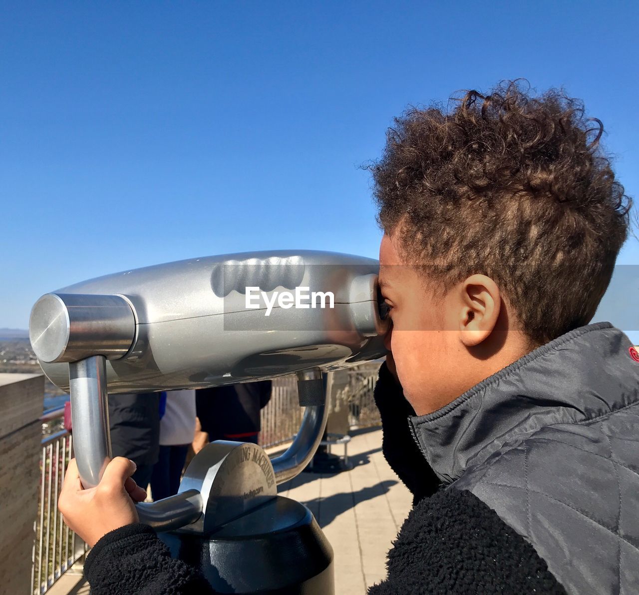 PORTRAIT OF BOY HOLDING CAMERA AGAINST CLEAR SKY