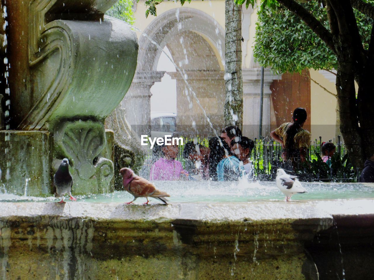 PEOPLE ON FOUNTAIN BY BUILDING