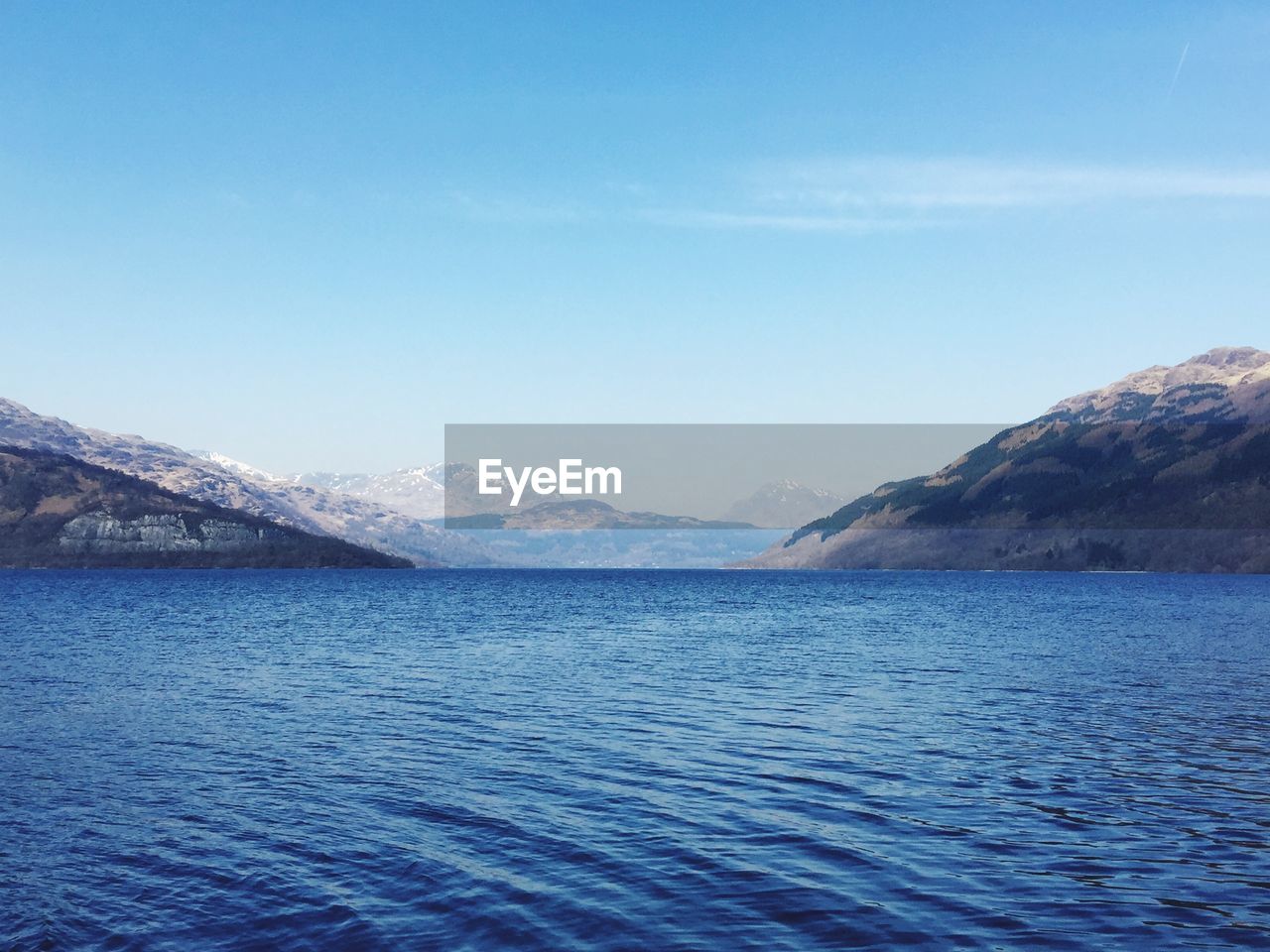 Idyllic shot of lake and mountains against sky