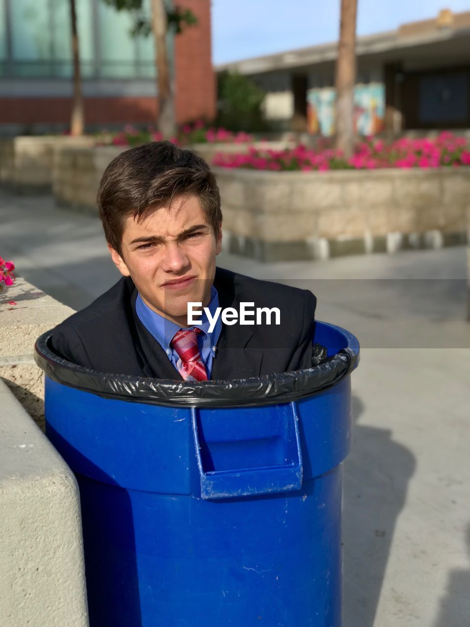 Portrait of young man in garbage bin