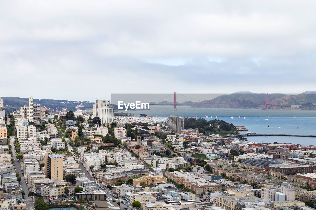 AERIAL VIEW OF CITY BY BUILDINGS AGAINST SKY