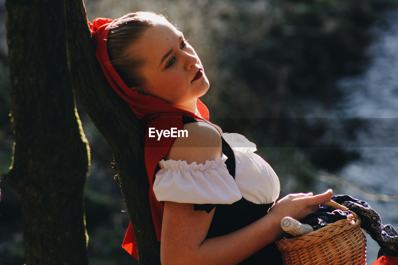 Close-up of thoughtful woman in costume standing in forest