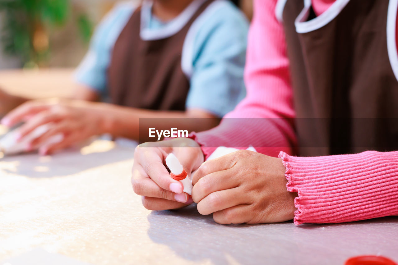 cropped hand of woman holding hands on table