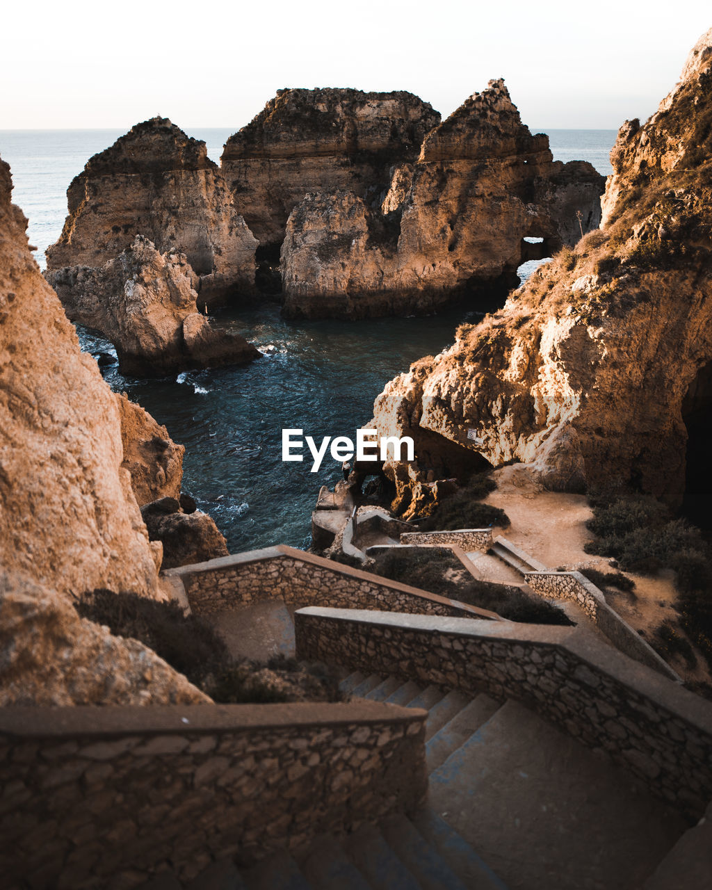 Rock formations by sea against sky