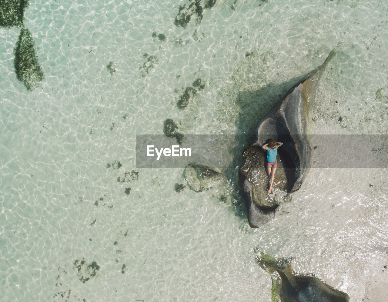 HIGH ANGLE VIEW OF BOY SWIMMING IN SEA