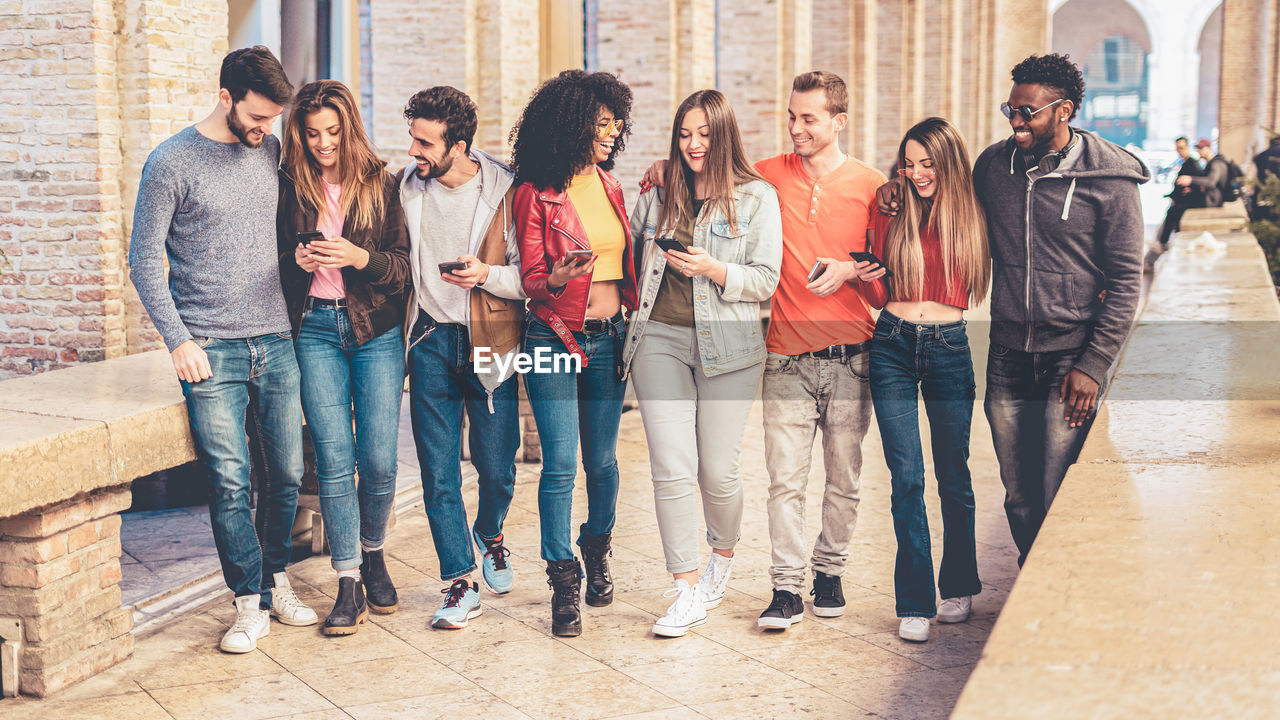 GROUP OF PEOPLE STANDING ON SIDEWALK