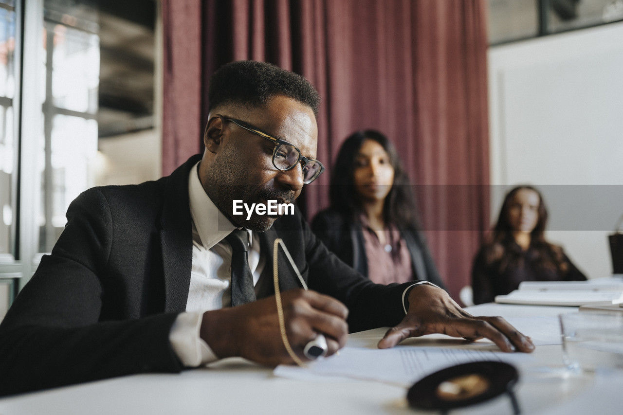 Mature businessman preparing strategy with colleagues in board room at office