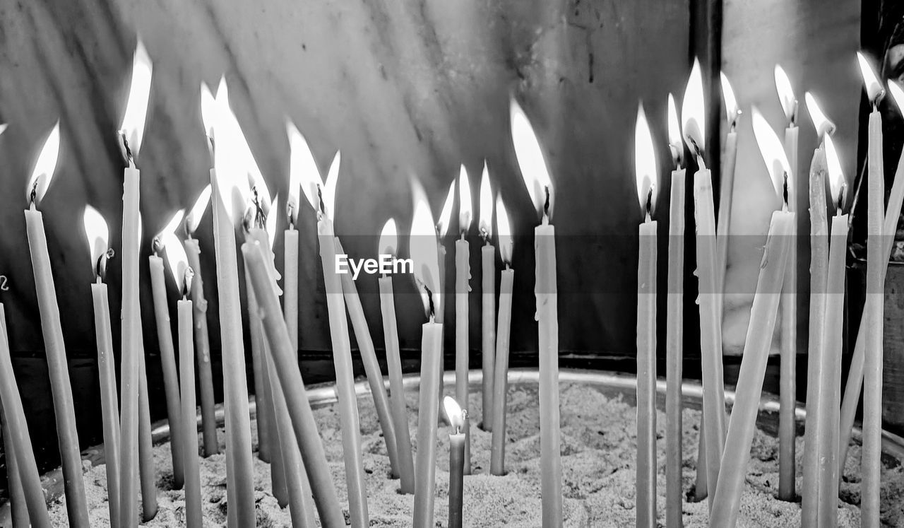 candle, burning, flame, fire, black and white, religion, belief, spirituality, place of worship, white, heat, no people, monochrome photography, large group of objects, lighting, monochrome, light, nature, built structure, close-up, indoors, architecture, illuminated, building, temple - building, in a row, iron, hanukkah, darkness