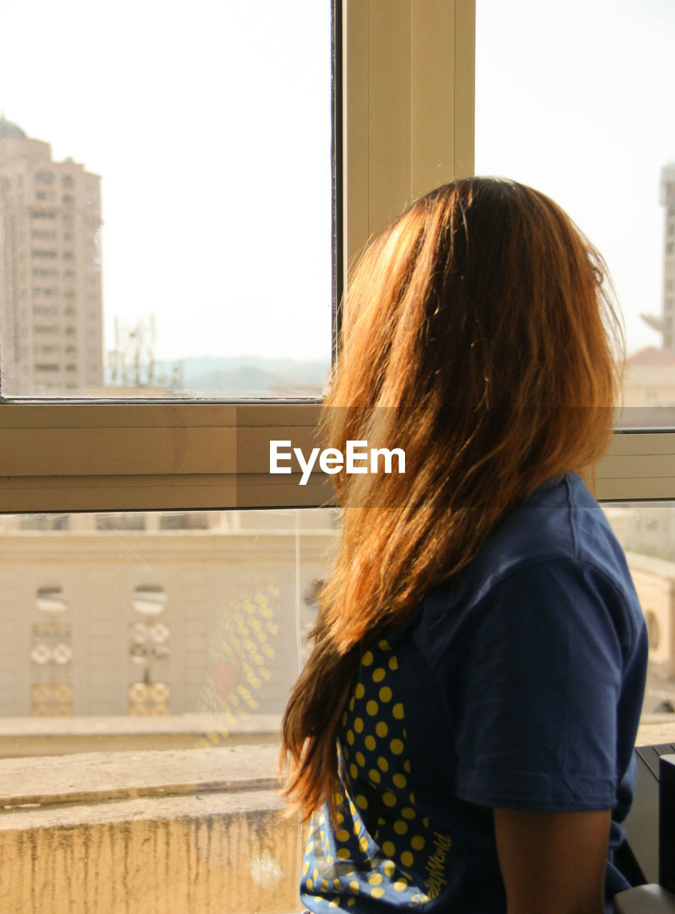 REAR VIEW OF WOMAN STANDING IN PARK