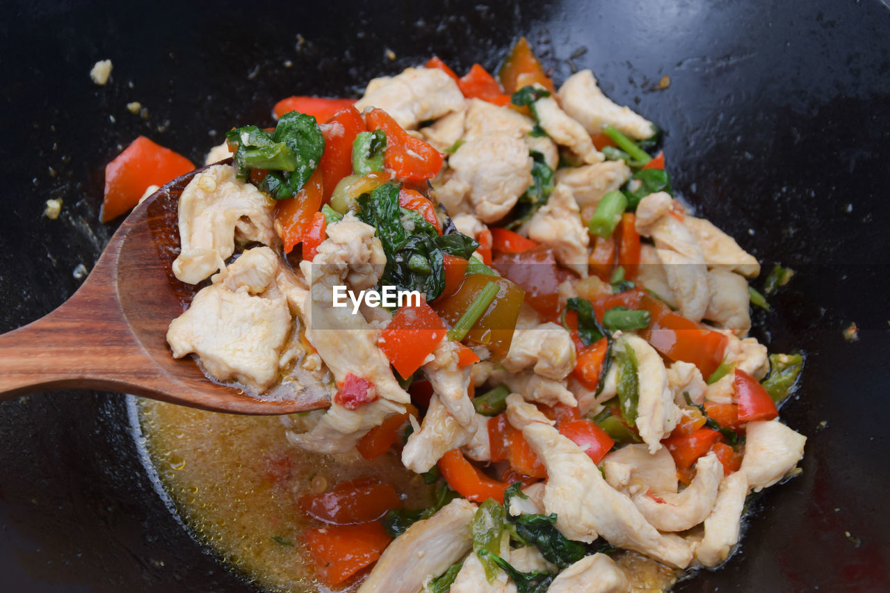 Basil chicken with spicy thai sauce - pad krapao gai cooking in wok