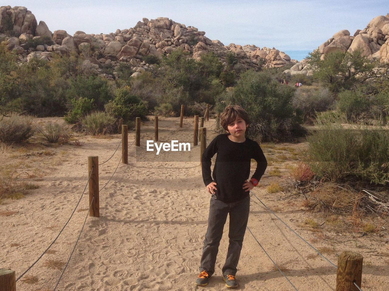 FULL LENGTH OF SMILING MAN STANDING ON MOUNTAIN