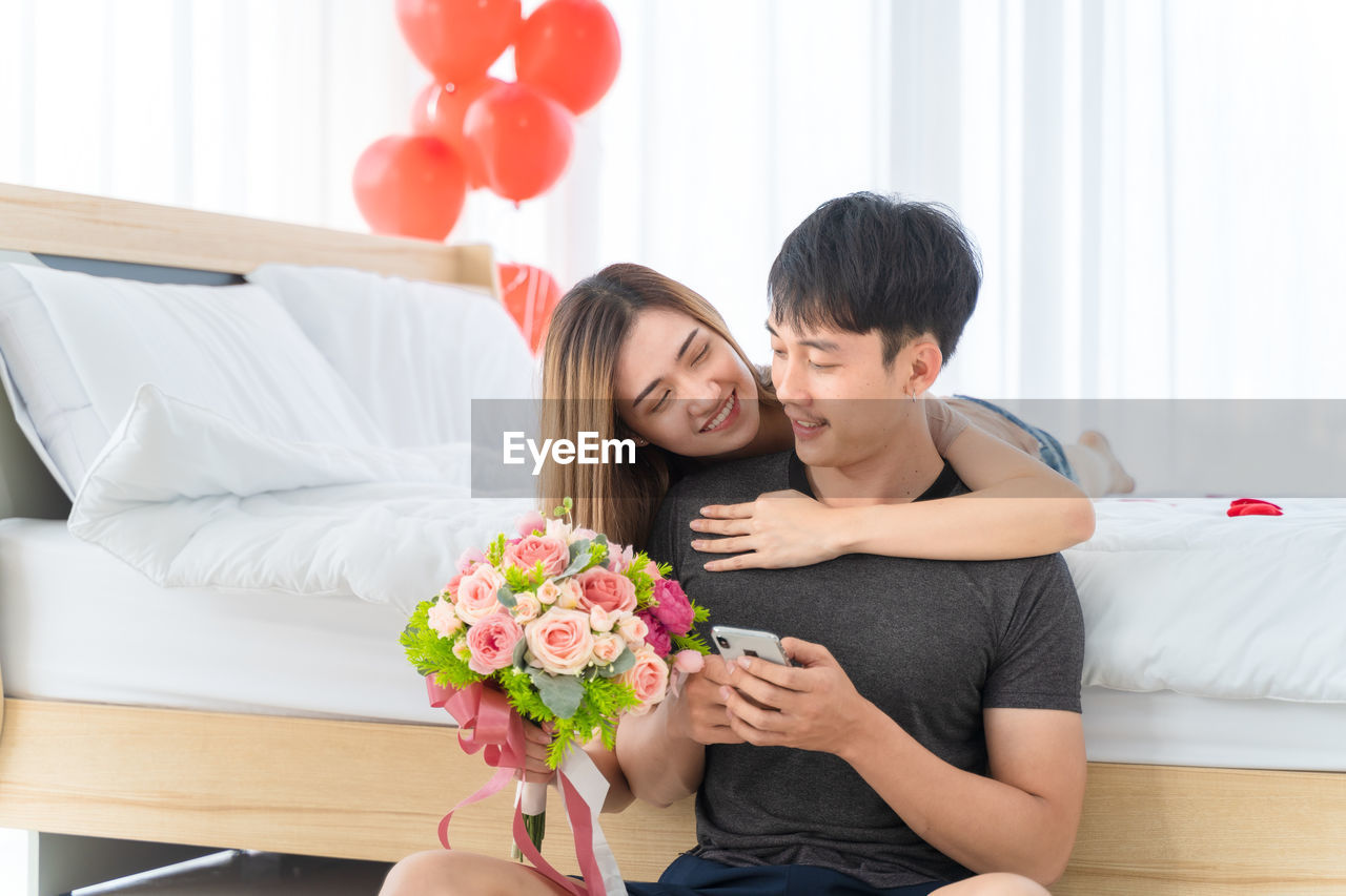 YOUNG COUPLE KISSING ON FLOWER