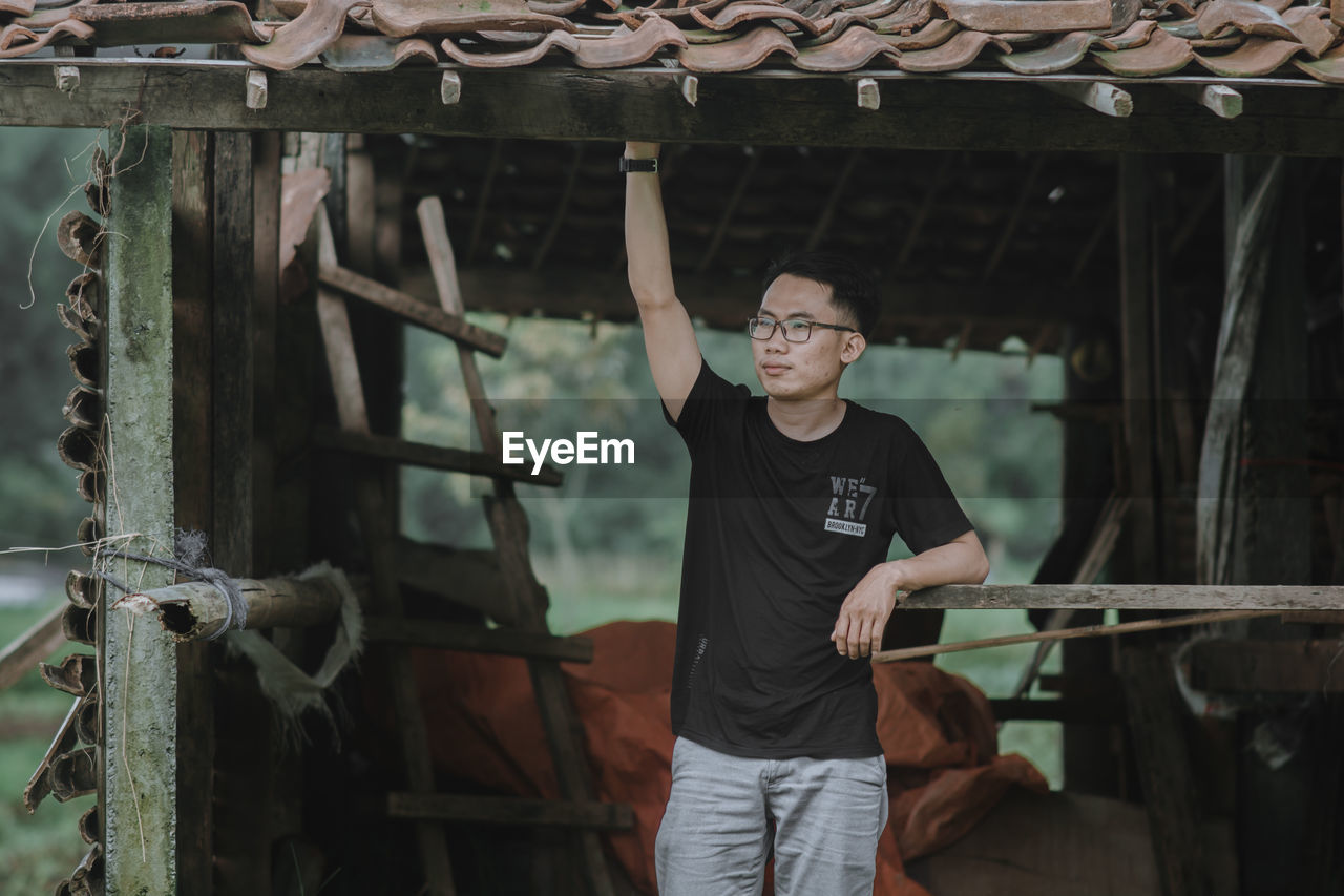 Full length of young man standing in front of built structure