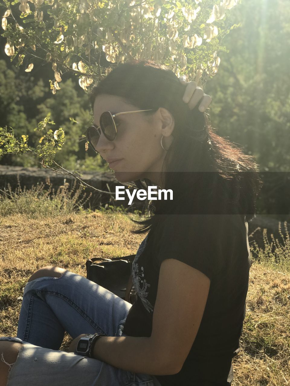 SIDE VIEW OF YOUNG WOMAN LOOKING AT CAMERA
