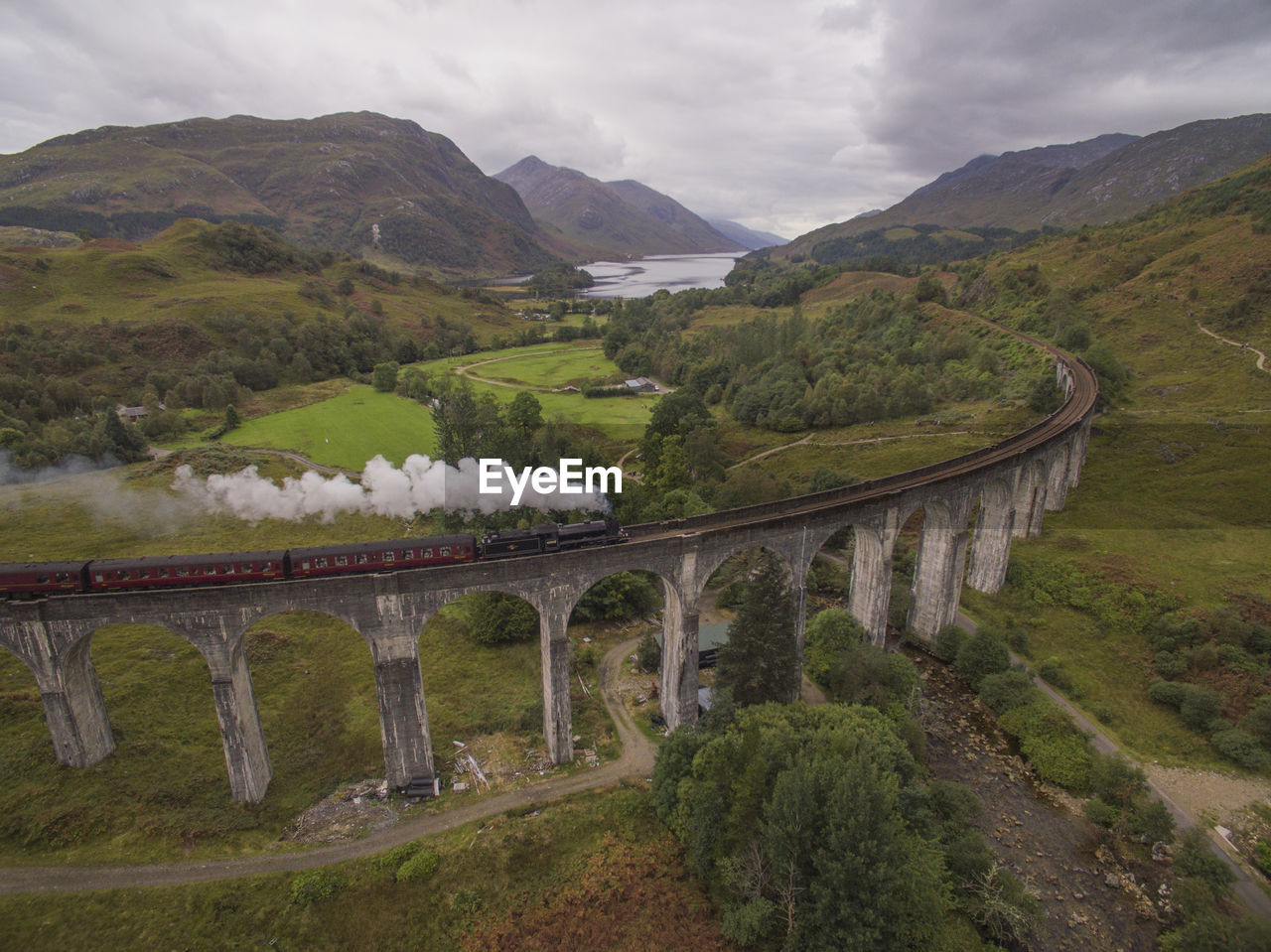 Arch bridge over mountains against sky