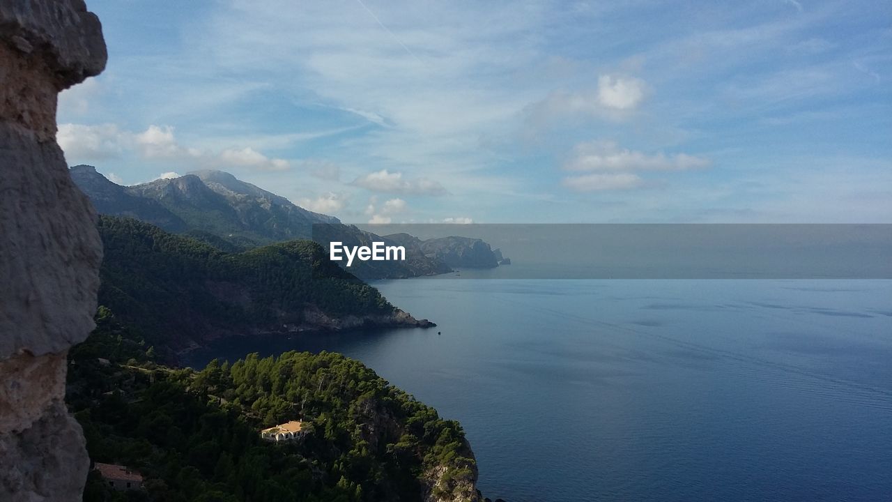 SCENIC VIEW OF SEA BY MOUNTAIN AGAINST SKY